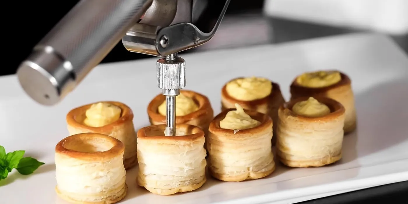 Filling puff pastry shells with cream using a stainless steel whipped cream dispenser